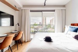 um quarto de hotel com uma cama com um chapéu em Charlie For You Moema em São Paulo