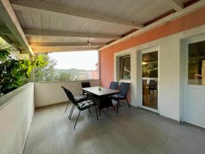 Un patio con una mesa y sillas en un balcón. en House with outdoor pool in Tisno, en Tisno