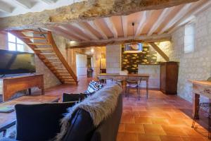 a living room with a couch and a table and a tv at Château de Candes - Art & Spa in Candes-Saint-Martin