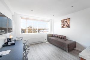 a living room with a couch and a window at Roland House in London