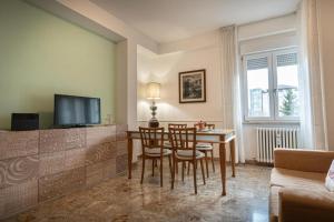 un salon avec une table, des chaises et une télévision dans l'établissement Appartamento Pennazzi, à Santa Maria degli Angeli