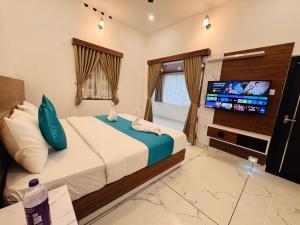a bedroom with a bed and a flat screen tv at Cloud Hills Munnar in Kallar Vattiyar