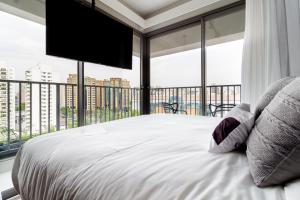 um quarto com uma cama grande e uma janela grande em Charlie For You Moema em São Paulo
