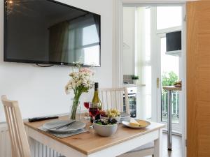 a dining room table with a television on a wall at The Downs in Torquay +13 photos