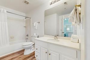 パナマ・シティ・ビーチにあるTropic Winds 2309の洗面台とトイレを備えた白いバスルーム +16枚の写真