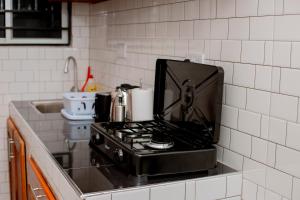 a stove top oven sitting on a counter in a kitchen at Reza stays apartment -Makumbusho behind Mwanga Tower in Dar es Salaam +35 photos