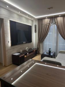 a living room with a flat screen tv on the wall at Apartman ANDJELIJA 3 in Bački Brestovac