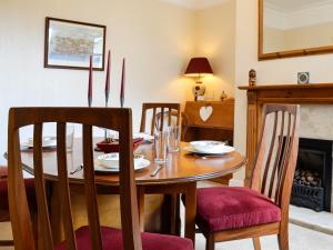 a dining room with a table and chairs and a fireplace at Robinson in Keswick
