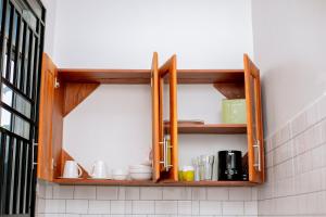a kitchen with wooden shelves with cups and dishes at Reza stays apartment -Makumbusho behind Mwanga Tower in Dar es Salaam