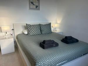 a bedroom with a bed with two black towels on it at B17 Caleton blanco in Tías +13 photos