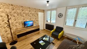 a living room with a tv and a couch and a table at Le Bélouga 4 Le Mont Dore 6pers in Mont-Dore