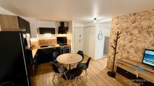 a kitchen and dining room with a table and chairs at Le Bélouga 4 Le Mont Dore 6pers in Mont-Dore