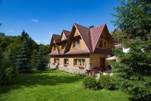 a large wooden house with a metal roof at Szarotka in Bukowina Tatrzańska