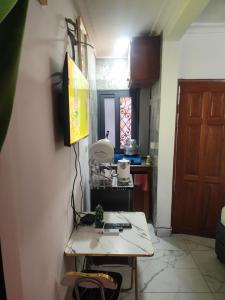 Una habitación con una mesa y una cocina con una puerta. en Kerole's House, en Douala