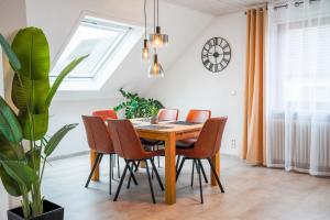 a dining room with a wooden table and chairs at Ferienwohnung am Schwarzwald in Althengstett