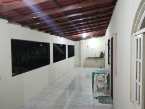 a hallway with a table and paintings on the walls at Casa Faé in Guarapari