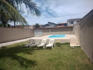 a group of chairs and a table and a pool at Casa Faé in Guarapari
