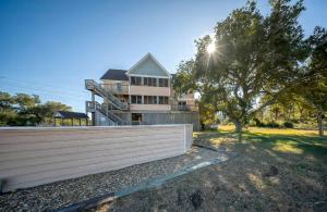 una casa con una valla delante de un árbol en 8700 - Southern Seasons, en Frisco