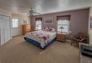 Un dormitorio con una cama y una silla y ventanas. en 8700 - Southern Seasons, en Frisco