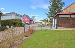 une clôture devant une maison avec une cour dans l'établissement Ferienhaus Waren Müritz, à Warenshof