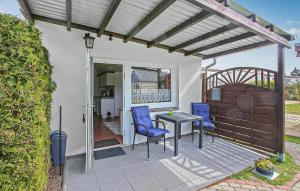un patio avec deux chaises bleues et une table dans l'établissement Ferienhaus Waren Müritz, à Warenshof