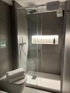 een badkamer met een glazen douche met toilet bij Loft Green Trani in Trani +24 foto's