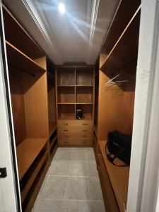 a walk in closet with wooden cabinets and shelves at IMMOloc in Libreville +6 photos