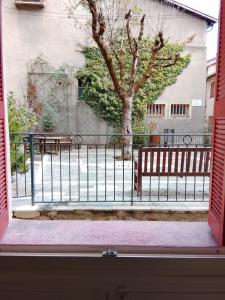 a window view of a fence and a tree at Superbe appartement au calme saint martin vésubie in Saint-Martin-Vésubie +4 photos