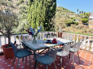 a table and chairs on a patio with a view at Villa Jina con piscina by At Home Costa del Sol in Torrox