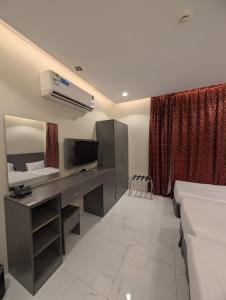 a bedroom with a desk and a bed and a television at فندق قربان in Al Madinah