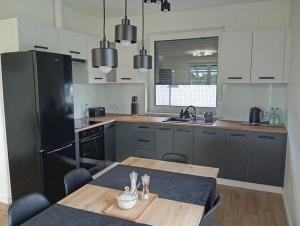 a kitchen with a table and a black refrigerator at Dom na Rzecznej in Schodnia Stara