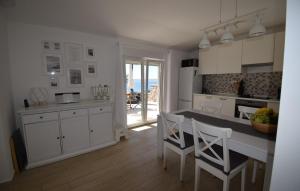 Una cocina con gabinetes blancos y una mesa y sillas. en Ferienhaus Katarina by Villas Guide, en Šarići