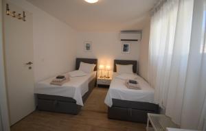 Dos camas en una habitación pequeña con paredes blancas. en Ferienhaus Katarina by Villas Guide, en Šarići