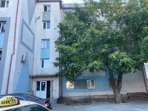 ein vor einem Gebäude mit einem Baum geparktes Auto in der Unterkunft Garsonieră stil hotel in Slatina
