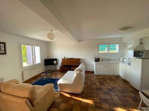 マルシー・レトワールにあるAppartement indépendant dans une maisonのソファとキッチンのあるリビングルーム