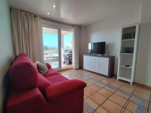 a living room with a red couch and a television at PoolParadise Tu mejor opción in San Jorge