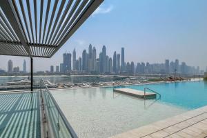 a swimming pool with a city skyline in the background at KeyRock - Dubai Marina Stay with Pool & Gym in Dubai +46 photos