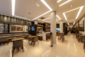 a restaurant with tables and chairs and a bar at Hotel Centro Europeu in Curitiba +58 photos