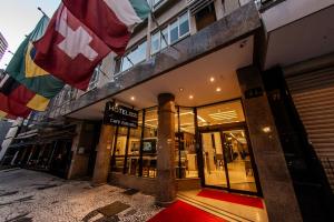 a store front with flags hanging outside of it at Hotel Centro Europeu in Curitiba