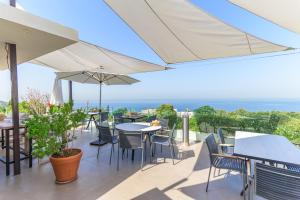 a patio with tables and chairs and an umbrella at Casa Plata 1 Bed With Jacuzzi in Batroûn