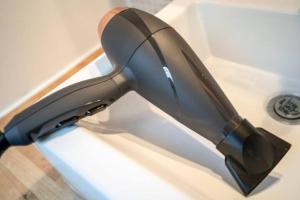 a hair dryer sitting on top of a sink at Small functional cocoon Ideal solution for students or professionals in Vaise