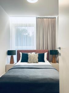 une chambre avec un lit avec deux lampes et une fenêtre dans l'établissement Stare Miasto z widokiem na ogród, bezpłatny parking, szybkie Wi-Fi, à Cracovie