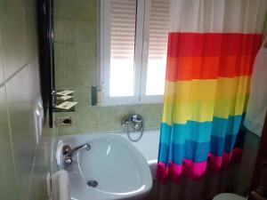 W łazience znajduje się prysznic z tęczą zasłoną i umywalka. w obiekcie Hotel Europa w mieście Tomelloso