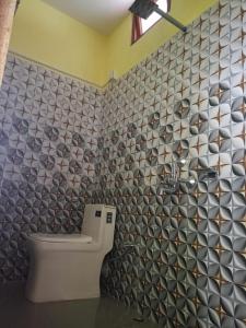 MangpuにあるRupsadeya Homestay Sittongのトイレとタイル張りの壁があるバスルーム