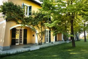 una casa gialla con alberi di fronte di Tenuta "La Meirana" - Gavi a Gavi