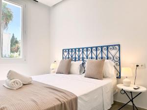 a white bedroom with two beds and a window at Nejma Apartment 2 bedrooms in Dar Mimoun Bey