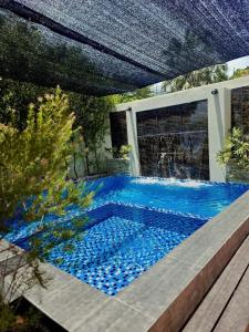 a swimming pool with blue tiles in a backyard at Max - Relax Staycation in Davao City +16 photos