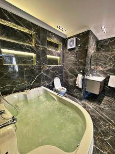 Un baño con bañera, inodoro y lavabo. en Roone pyramids view hotel, en El Cairo 39 fotos más