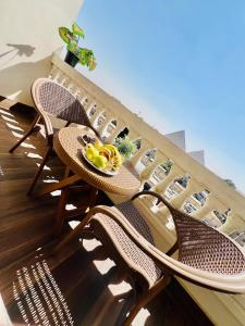 un balcón con mesa y sillas y un bol de fruta en Roone pyramids view hotel, en El Cairo
