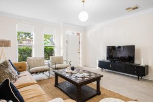 a living room with a couch and a coffee table at North Adelaide Townhouse in North Adelaide